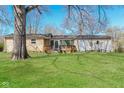 A spacious backyard with a well-maintained lawn and a small wooden deck accessible through sliding glass doors at 9535 E Michigan St, Indianapolis, IN 46229