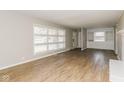 Bright living room featuring laminate flooring, built-in shelving and a large window at 9535 E Michigan St, Indianapolis, IN 46229