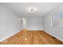 Open living room showcasing hardwood floors, neutral walls, and ample natural light streaming through the window at 9814 E 17Th St, Indianapolis, IN 46229