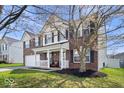 Attractive brick two-story house featuring a welcoming front porch and beautiful yard at 10883 Balfour Dr, Noblesville, IN 46060