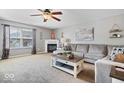 Bright and airy living room with a fireplace, ceiling fan, and comfortable sectional sofa at 10883 Balfour Dr, Noblesville, IN 46060