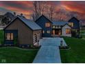 Beautiful exterior of this two-story home with long driveway, manicured lawn, and modern design at dusk at 1333 Chatham Rdg Ct, Westfield, IN 46074