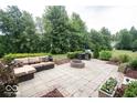 Outdoor patio featuring a comfortable seating area, fire pit, and grill, perfect for entertaining guests in a serene backyard setting at 13717 Van Buren Pl, Fishers, IN 46038