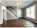 Bright living room with hardwood floors, stairway, and a large window at 1378 Hannibal St, Noblesville, IN 46060