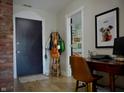 Welcoming entryway features a modern design with a rustic brick accent wall and stylish decor, blending comfort and sophistication at 1404 Broadway St # Apt G, Indianapolis, IN 46202