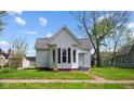 Exterior view of home with red brick foundation, light siding, and inviting curb appeal at 1509 Sycamore St, Columbus, IN 47201