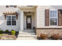 Inviting front porch featuring brick accents, white columns, and a decorative wreath on the front door at 15655 Woodford Dr, Westfield, IN 46074