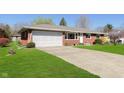 Brick home with a large driveway, lawn, and an attached two car garage at 166 N Post Rd, Indianapolis, IN 46219
