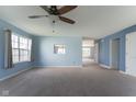 Spacious living room featuring light blue walls, neutral carpet, and a ceiling fan at 1809 Ernest Ct, Indianapolis, IN 46234