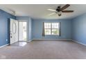 Open living room with neutral carpet, a ceiling fan, and an open front door at 1809 Ernest Ct, Indianapolis, IN 46234