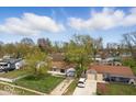 An aerial view of a cozy single-Gathering home showcasing a car parked in the driveway and mature trees at 2219 N Webster Ave, Indianapolis, IN 46219