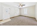 Cozy living room with neutral carpet, decorative front door, and bright natural light at 225 E 36Th St, Anderson, IN 46013