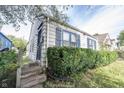 This home features an entrance on the side and blue shutters that complement the exterior at 270 S Lasalle St, Indianapolis, IN 46201