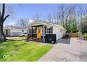 Charming home featuring a bright yellow door, inviting front porch, fresh landscaping, and long drive way at 3134 Orchard Ave, Indianapolis, IN 46218