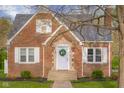 A brick home showcasing a classic facade, complemented by a decorative front door at 3221 Washington St, Columbus, IN 47203
