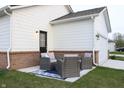 Private outdoor patio featuring stylish furniture, a brick foundation, and a convenient access door to the house at 360 Lincoln W Cir, Fortville, IN 46040