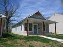 Charming home featuring a cozy front porch with red wood pillars and light blue front door at 4234 Kingsley Dr, Indianapolis, IN 46205
