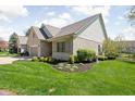 Well-maintained brick home with manicured landscaping and a view of a nearby body of water at 4557 Marigold Ct, Greenwood, IN 46143