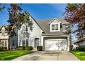 Traditional home with a gable roof, dormer windows, attached garage, and mature trees at 5034 N Illinois St, Indianapolis, IN 46208