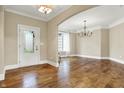 Elegant entryway featuring hardwood floors, an arched doorway, and a chandelier at 5212 Knollton Rd, Indianapolis, IN 46228