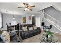 Open-concept living room showcasing a comfortable sofa, dining area, staircase, and neutral wall color at 5453 Nighthawk Way, Indianapolis, IN 46254