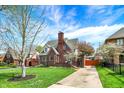 Beautiful Tudor-style house featuring brickwork, a chimney, and a well-kept front lawn at 5611 N Delaware St, Indianapolis, IN 46220