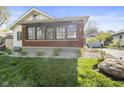 Charming home with brick enclosed porch, landscaped front yard, and detached garage at 617 Carlyle Pl, Indianapolis, IN 46201