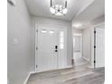 Inviting foyer with gray walls, light wood-look flooring, and a stylish modern light fixture at 6218 Churchman Way, Indianapolis, IN 46237