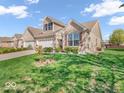 Inviting brick townhome featuring a lush green lawn and beautiful landscaping at 6502 E Walton Dr, Camby, IN 46113