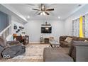 Spacious living room with a cozy sectional, ceiling fan, and large screen television offers a comfortable gathering space at 6536 W Shoreline Ct, Greenfield, IN 46140