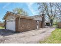 A brick house showing the two-car garage, chimney, back door, and fenced-in back yard at 8051 Sycamore Springs Trl, Indianapolis, IN 46239