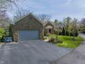 Charming stone home with a well-maintained front yard and attached two-car garage at 8069 Middle Bay Ln, Indianapolis, IN 46236