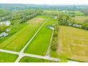 Expansive aerial view of the home on lush acreage, including a pond and nearby wooded area at 8850 W 225 S, Columbus, IN 47201