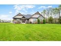 Beautifully landscaped home with stone accents and a lush green lawn in a wooded area at 8850 W 225 S, Columbus, IN 47201