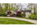 Elegant stone home with a large front yard, mature trees, and a beautiful deck perfect for outdoor relaxation at 8901 Shetland Ln, Indianapolis, IN 46278