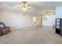 Inviting living room featuring neutral walls, a ceiling fan, and seamless flow into dining area at 10822 Cape Coral Ln, Indianapolis, IN 46229