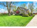 A classic home design with a spacious, well-maintained lawn, complemented by trimmed hedges and mature trees at 110 W Buckeye St, Cicero, IN 46034