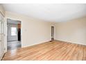 Inviting living room with gleaming hardwood floors and doorway leading to kitchen and hall at 1231 Nester St, Speedway, IN 46224