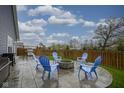 Backyard featuring a stone fire pit, blue Adirondack chairs, and a stainless-steel grill at 1299 W Crystal Dr, Fortville, IN 46040