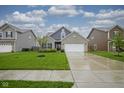 Well-maintained home features green lawn and an attached two-car garage at 1299 W Crystal Dr, Fortville, IN 46040