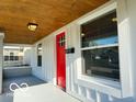 Inviting covered front porch with a bright red front door and ample natural light at 1510 W 22Nd St, Indianapolis, IN 46202