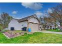 View of the home's side exterior, attached garage and landscaped yard at 1910 Riverstone Ct, Westfield, IN 46074