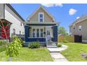 Charming home with a welcoming front porch, landscaped yard, and a classic two-story design at 2005 Carrollton Ave, Indianapolis, IN 46202