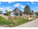 Charming two-story home with white siding, blue shutters, covered front porch and fenced yard at 222 Raines St, Plainfield, IN 46168