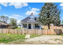 Charming two-story home with white siding, blue shutters, covered front porch and fenced yard at 222 Raines St, Plainfield, IN 46168