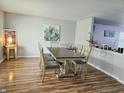 Bright dining room boasts wood floors, a large table with seating for six, and colorful art at 2348 Shadowbrook Dr, Plainfield, IN 46168