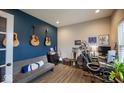 This spacious home office features a blue accent wall, wood-look flooring, and ample natural light at 3235 Myrtle Dr, Lapel, IN 46051