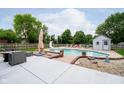 Relaxing backyard with an in-ground pool, lounge chairs, and a shed at 324 Palmyra Dr, Indianapolis, IN 46239