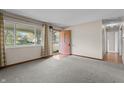 Neutral carpeted living room featuring a bright window and an exterior door at 3561 Winings Ave, Indianapolis, IN 46221