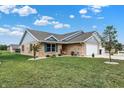 Attractive brick home with a well-maintained lawn, lovely landscaping, and a two-car garage at 400 E Charter Dr, Muncie, IN 47303